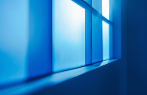 The blue background of a window, with light coming from behind it and reflecting on its surface. The window is illuminated by a beam that creates an atmosphere of calmness and peace.